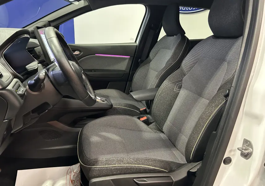 Vue intérieure côté conducteur de la Renault Symbioz E-Tech blanc nacré, sièges tissu gris et volant multifonction.