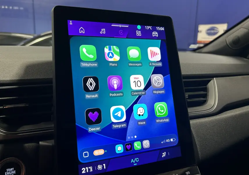 Écran tactile central affichant des applications connectées dans l'habitacle d'une Renault Symbioz blanc nacré, vue de profil droit.