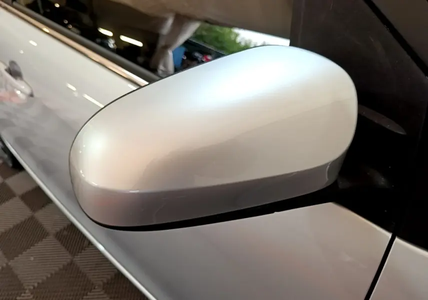 Rétroviseur côté conducteur gris clair de la Citroën C1 VTi 72 Shine, vue rapprochée sur la portière avant.