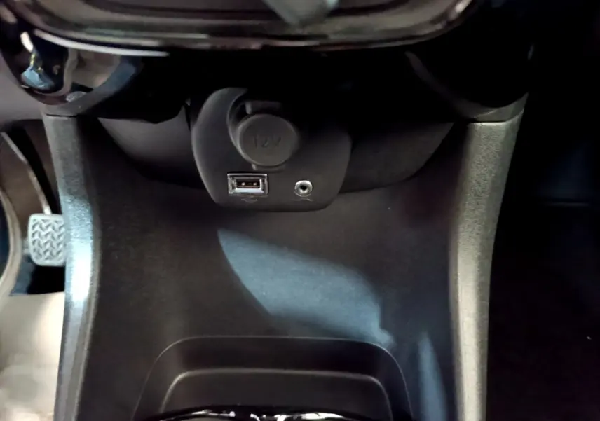 Vue rapprochée de la prise 12V et port USB dans l’habitacle noir du Citroën C1 gris clair, version Shine 2019.