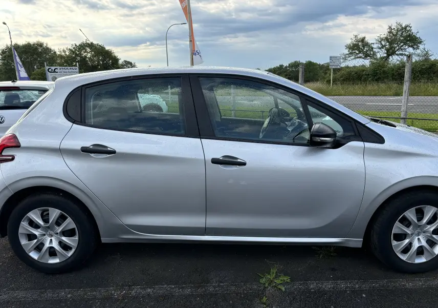 Profil côté gauche d'une Peugeot 208 gris argent 5 portes de 2017, avec jantes alliage et rétroviseur noir.