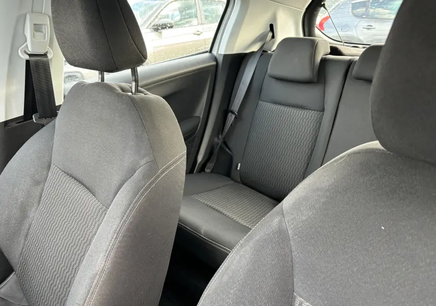 Intérieur noir en tissu de la Peugeot 208 1,6L HDI Active 2017, vue rapprochée des sièges avant et arrière.