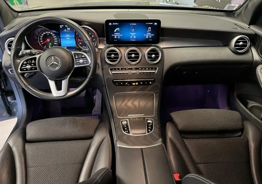 Vue intérieure du tableau de bord et console centrale du Mercedes GLC 2019 avec volant cuir noir et écran tactile.