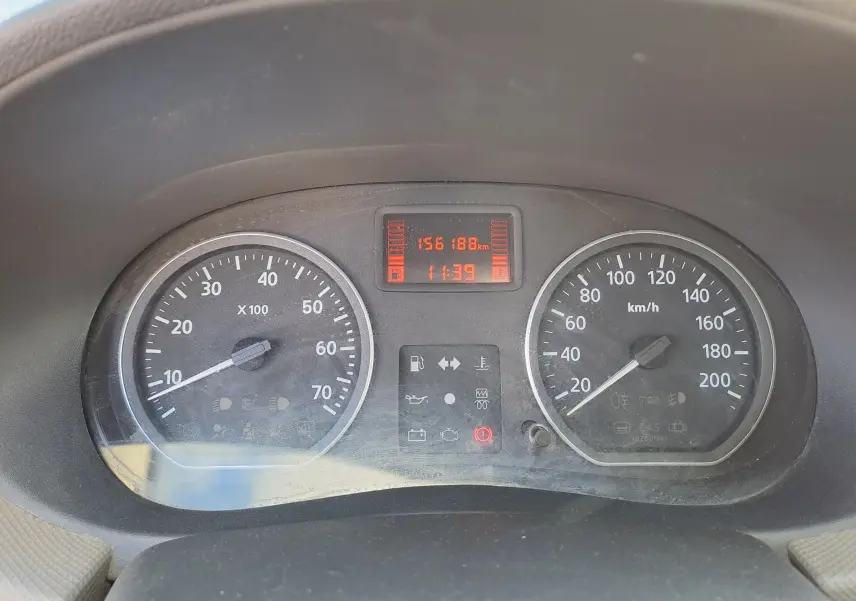 Tableau de bord de Dacia Sandero 2010 montrant compteur vitesse et compte-tours avec affichage digital rouge.