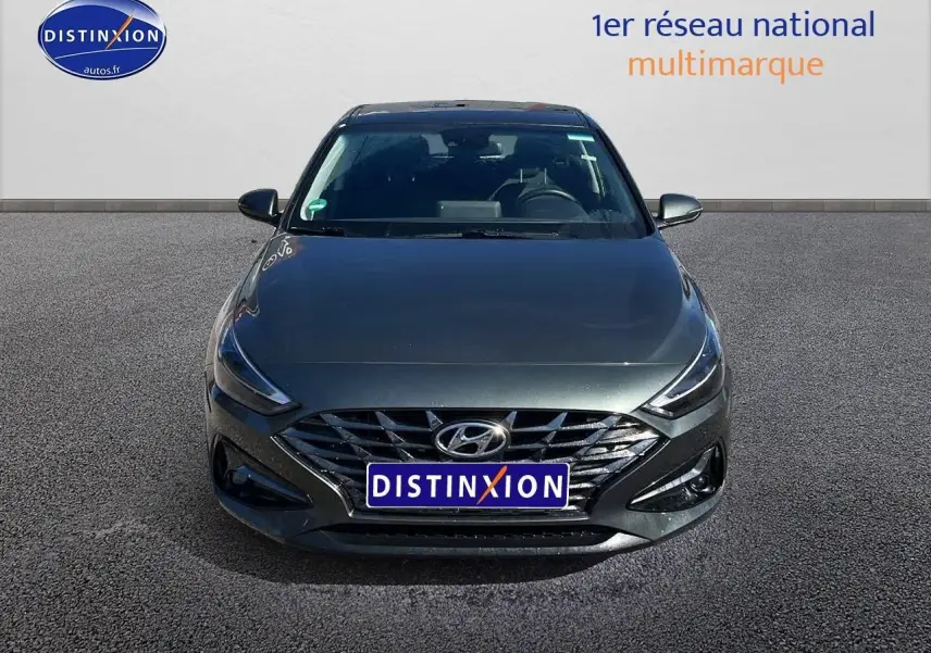 Vue frontale d'une Hyundai i30 gris argent 2024 avec calandre chromée et phares LED distinctifs.