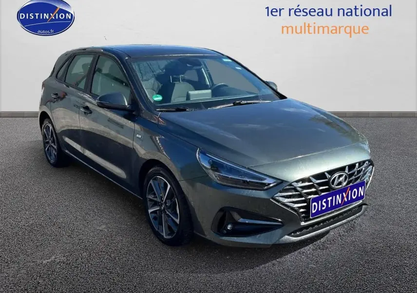 Hyundai i30 gris argent vue 3/4 avant droit avec calandre chromée et jantes alliage modernes