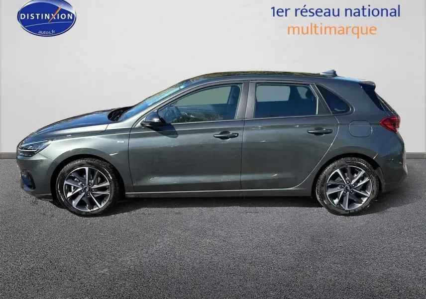 Profil côté gauche d'une Hyundai i30 gris argent 2024 avec jantes alu et feux arrière à LED visibles.