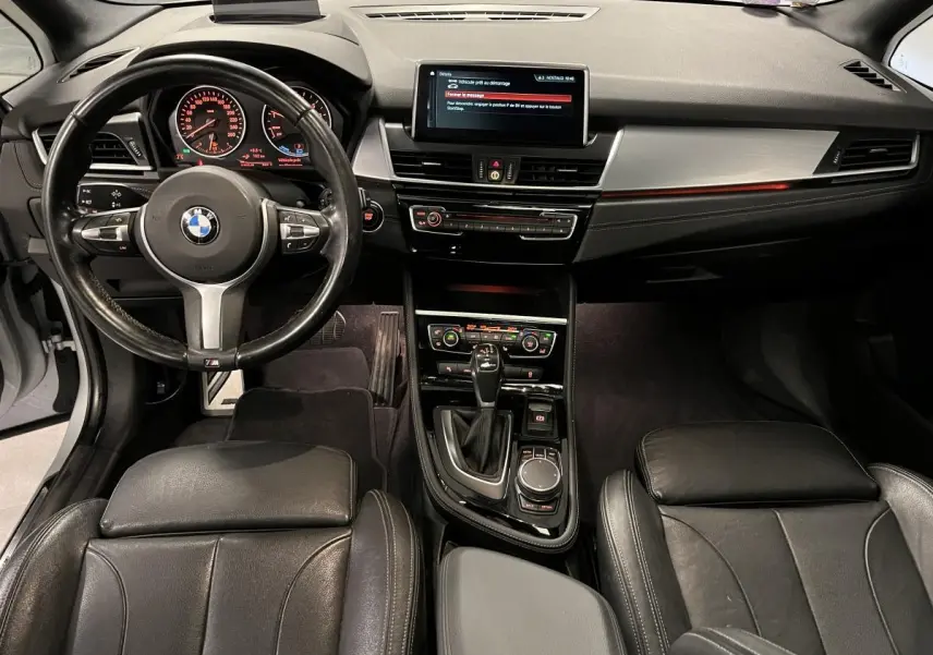 Vue intérieure avant de la BMW Série 2 225xe M Sport avec tableau de bord noir et console centrale moderne.