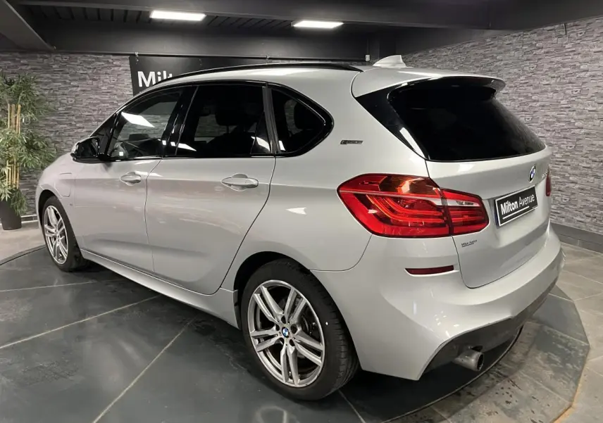 BMW Série 2 225xe Active Tourer gris vue 3/4 arrière droit avec jantes alliage et vitres teintées.