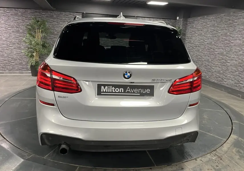 Vue arrière d'une BMW Série 2 225xe Active Tourer gris métallisé avec logo et feux rouges allongés.