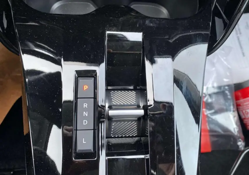 Gros plan sur la console centrale noire brillante avec sélecteur de boîte automatique et molette de réglage du Citroën C3 Aircross 2025.