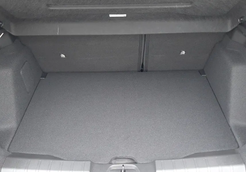 Vue intérieure du coffre spacieux et propre du Jeep Avenger 2025, finition Storm Grey avec toit noir, sans chargement visible.