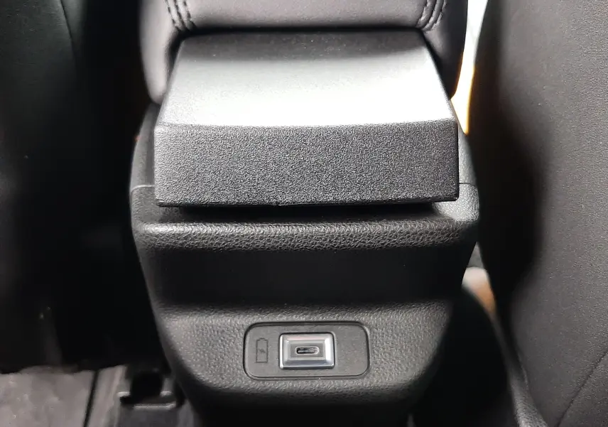 Gros plan sur la console centrale arrière noire du Jeep Avenger 2025 avec prise USB visible entre les sièges.