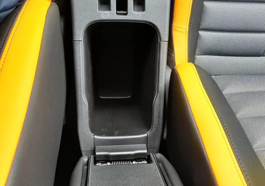 Gros plan sur la console centrale entre les sièges avant orange et gris du Jeep Avenger 2025 finition The North Face.