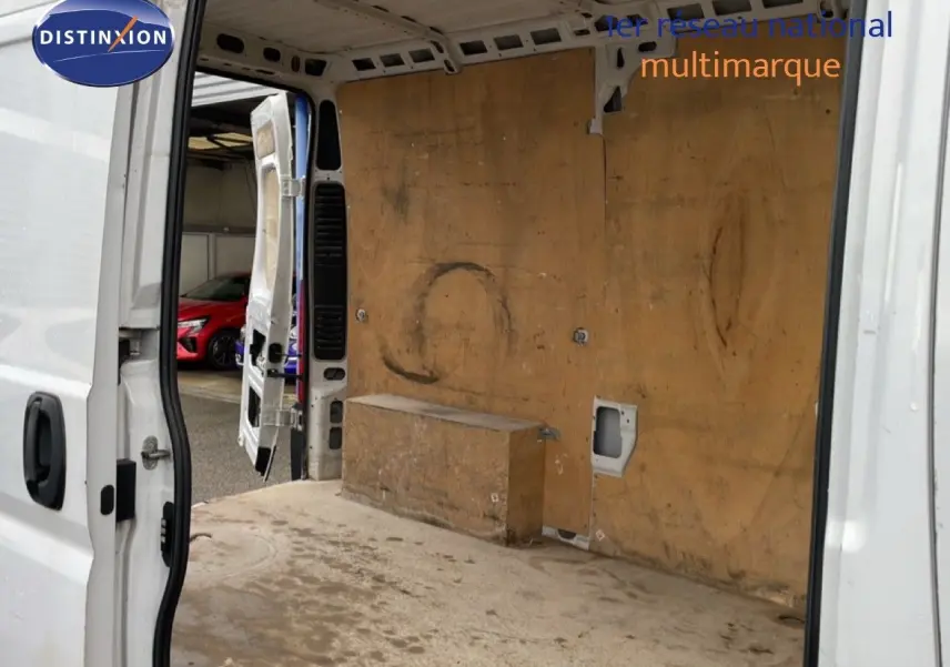 Vue arrière ouverte du FIAT Ducato Fourgon blanc de 2014, montrant l’intérieur utilitaire en bois usé.