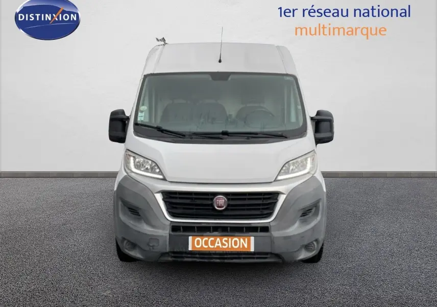 Vue frontale d’un fourgon Fiat Ducato blanc de 2014 avec calandre noire et plaque "OCCASION" orange.