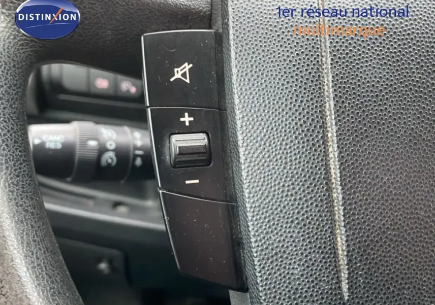 Gros plan sur les commandes du volant du Fiat Ducato Fourgon blanc, montrant les boutons de volume et de sourdine.