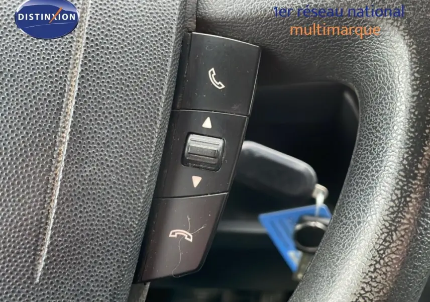 Gros plan sur les commandes téléphoniques au volant en cuir noir du Fiat Ducato Fourgon blanc, version 2014.