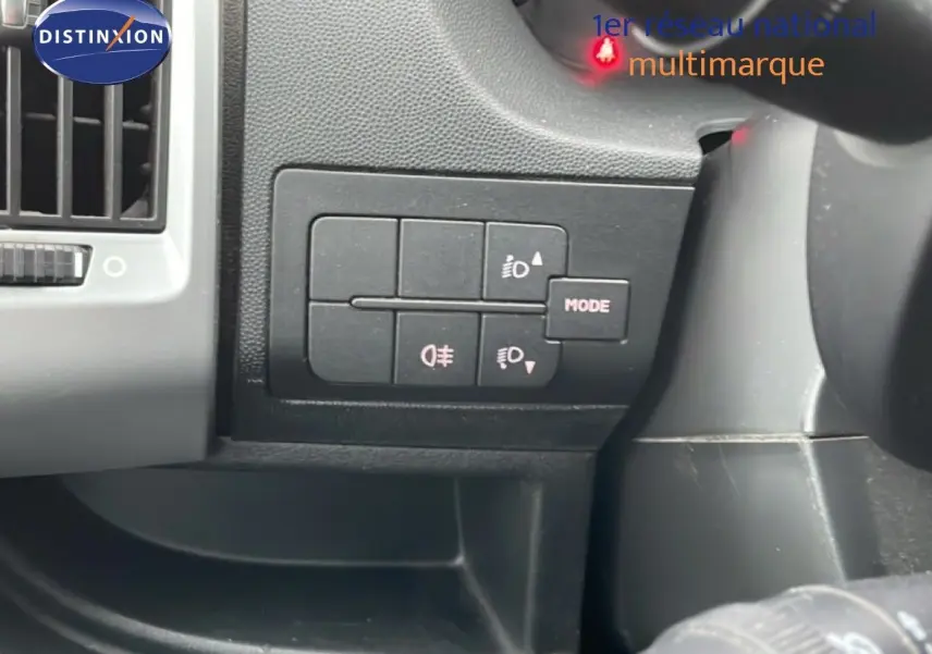 Gros plan sur les commandes d’éclairage à gauche du volant dans l’habitacle du Fiat Ducato Fourgon blanc de 2014.
