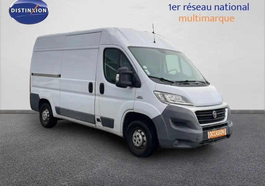 Fiat Ducato Fourgon blanc vu en 3/4 avant droit, avec pare-chocs et protections latérales noires.