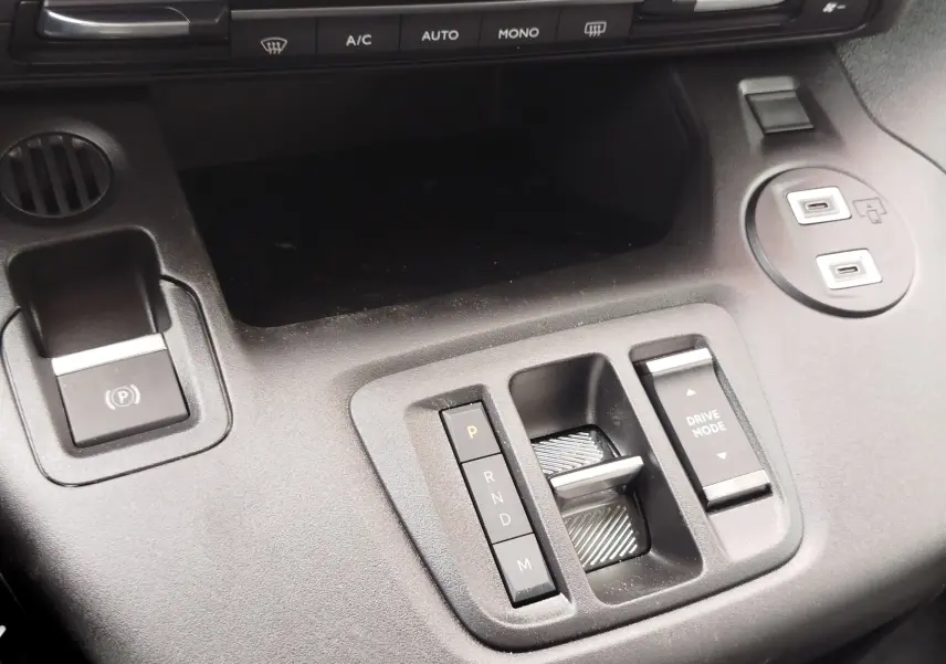 Gros plan sur la console centrale noire du Citroën Berlingo 2025, avec commandes de boîte auto et boutons Drive Mode.