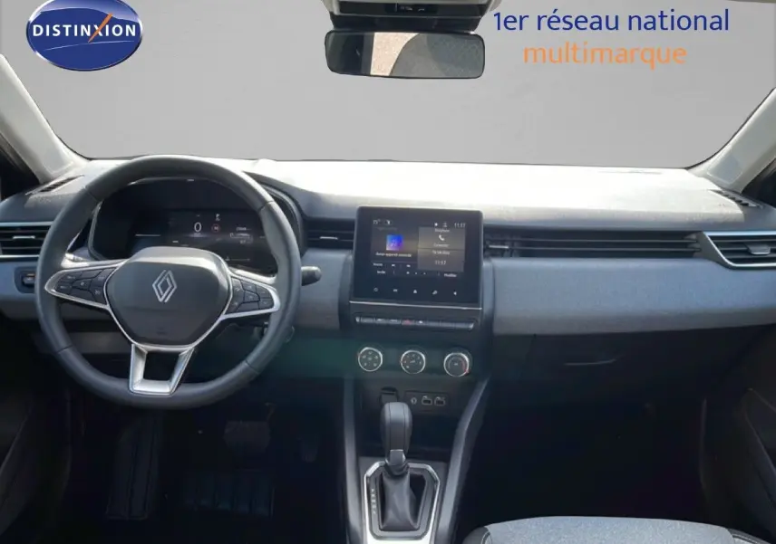 Vue intérieure avant de la Renault Clio 2025, tableau de bord moderne avec écran tactile et volant multifonction noir.