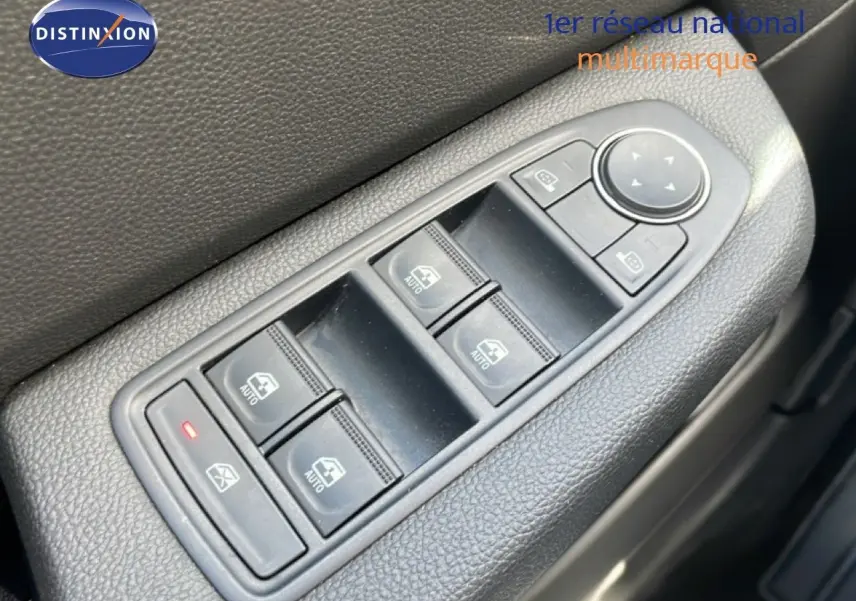 Gros plan sur les commandes de lève-vitres et rétroviseurs côté conducteur de la Renault Clio gris schiste métal 2025.