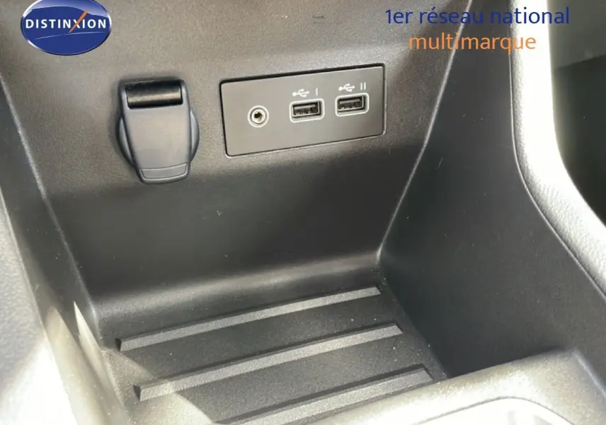 Gros plan sur la console centrale intérieure de la Renault Clio 2025, montrant prises USB et prise auxiliaire.