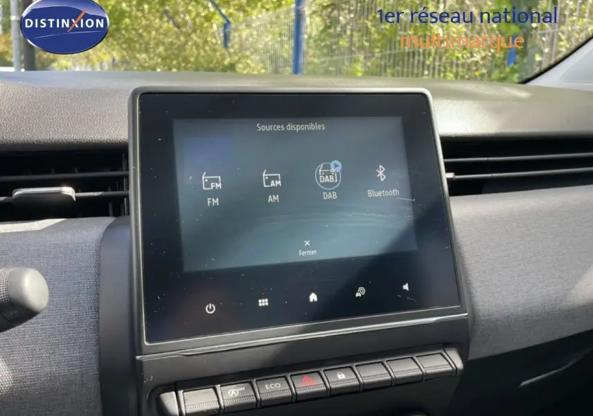 Vue intérieure centrée sur l’écran tactile multimédia de la Renault Clio gris schiste, soulignant les commandes et l’affichage digital.