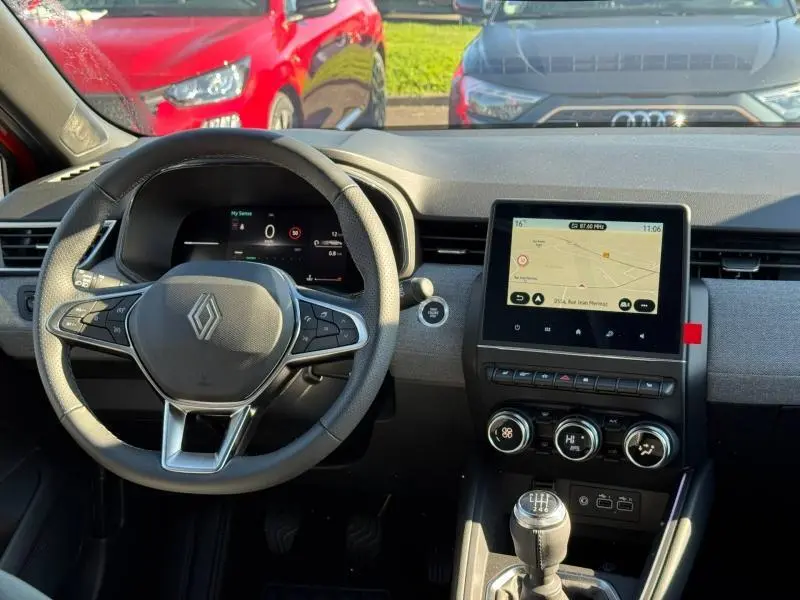 Vue intérieure avant de la Renault Clio 1.0 TCe 90ch Techno 2025, volant multifonction et écran tactile avec GPS visible.