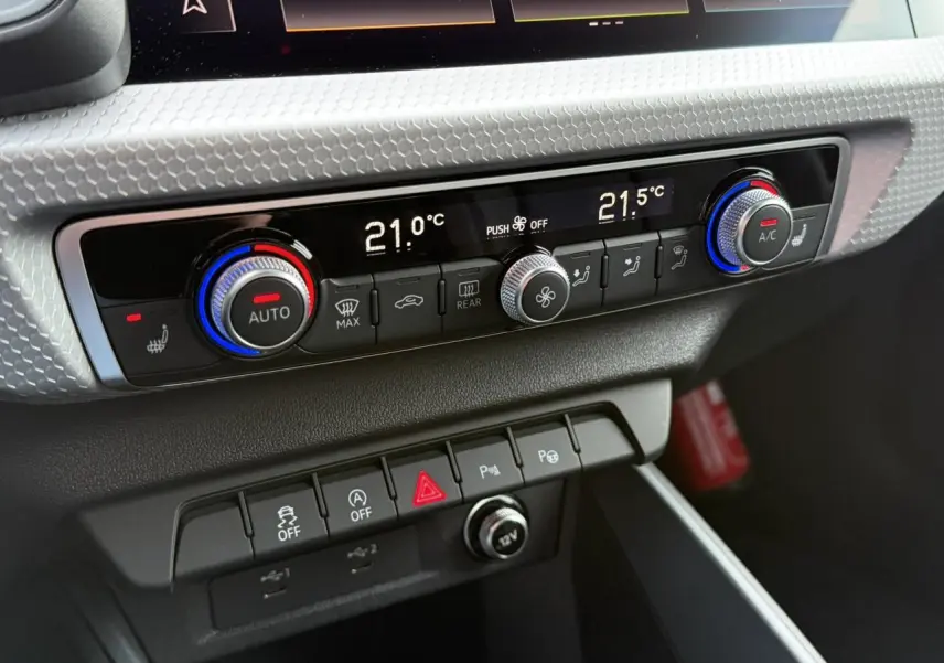 Détail du tableau de bord de l'Audi A1 Sportback 30 TFSI 2023 montrant la console de climatisation et les commandes en noir et argent.