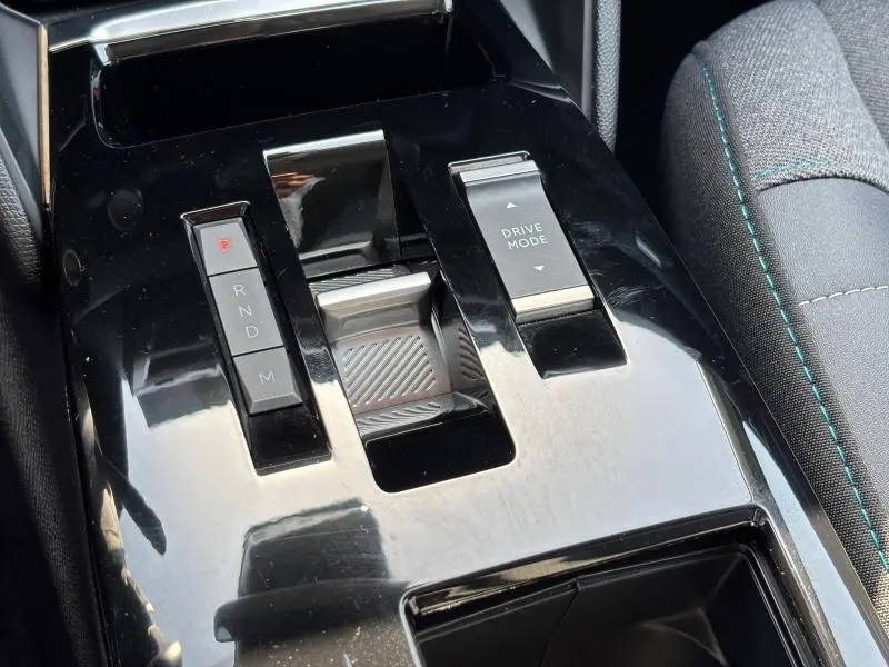 Gros plan sur la console centrale noire brillante de la Citroën C4 X avec commandes boîte auto et mode de conduite.