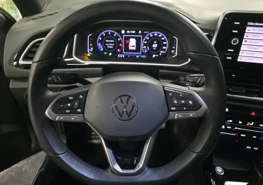 Vue rapprochée du volant noir R-Line et du tableau de bord digital du Volkswagen T-Roc 2025.