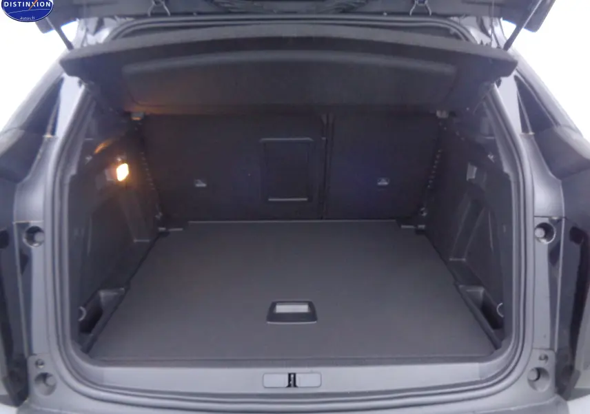Coffre ouvert d'un Peugeot 3008 noir perle métal, vue arrière montrant un espace de chargement spacieux et bien éclairé.