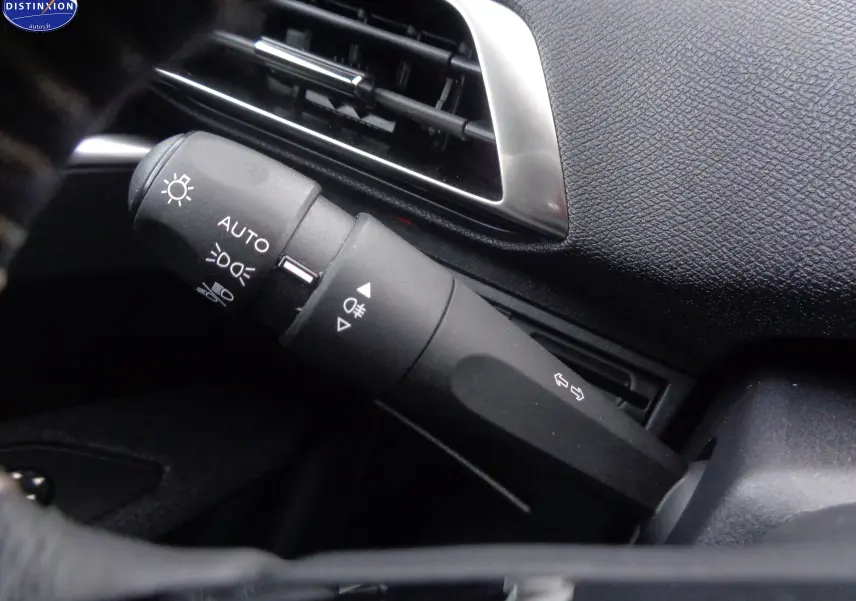 Gros plan sur la commande des feux et clignotants dans l’habitacle noir du Peugeot 3008 2023.