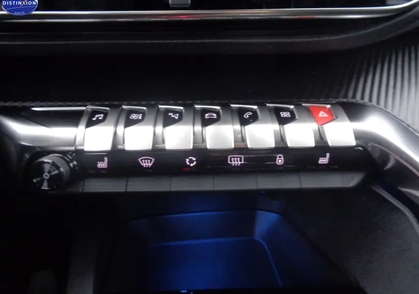 Gros plan sur la rangée de boutons argentés et noirs du tableau de bord du Peugeot 3008 noir perle métal, avec éclairage bleu dessous.