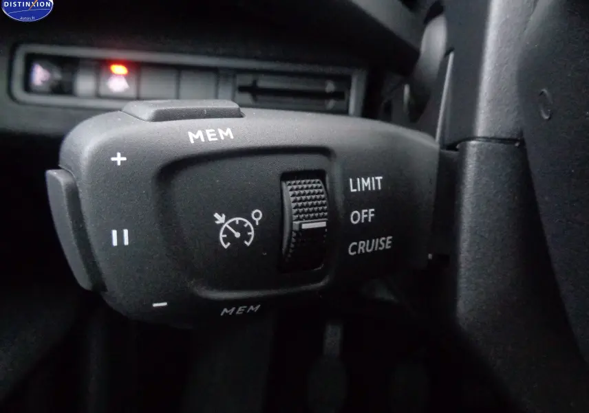 Gros plan sur la commande de régulateur de vitesse dans l'habitacle du Peugeot 3008 noir perle métal 2023.