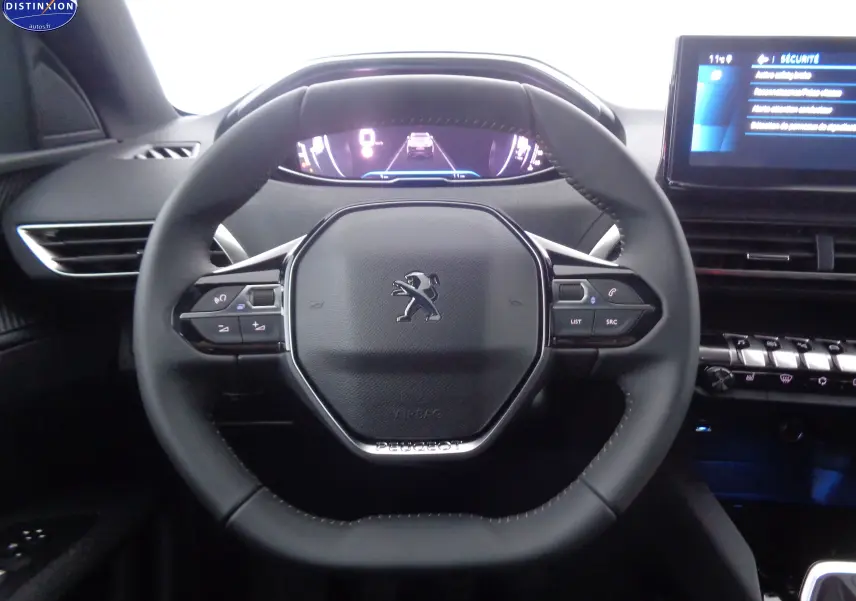 Vue centrée sur le volant noir du Peugeot 3008 2023, avec tableau de bord numérique et écran tactile visible.