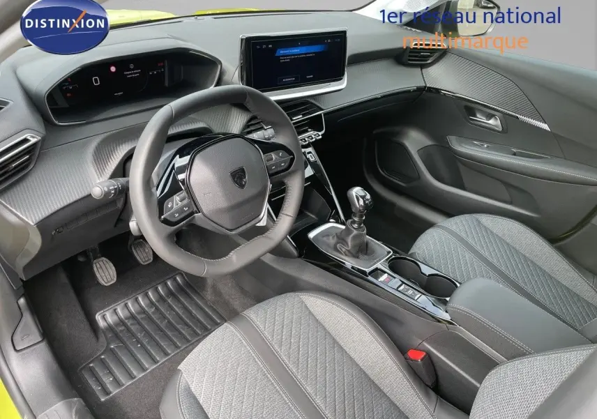 Vue intérieure côté conducteur de la Peugeot 208 1.2 PureTech 100ch Allure avec tableau de bord moderne et sièges gris.