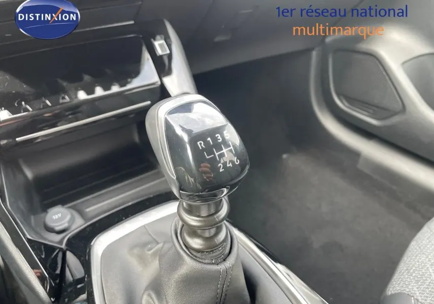 Le levier de vitesses manuel en gros plan dans l'habitacle d'une Peugeot 208 jaune Agueda Metal.