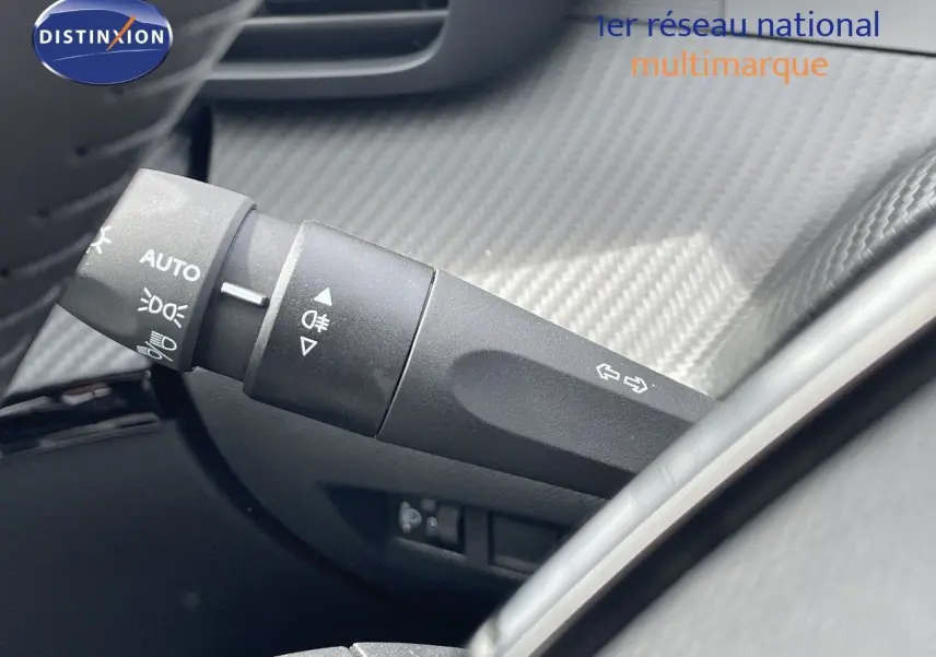 Gros plan sur la manette de clignotants noire dans l’habitacle d’une Peugeot 208 jaune Agueda Metal.