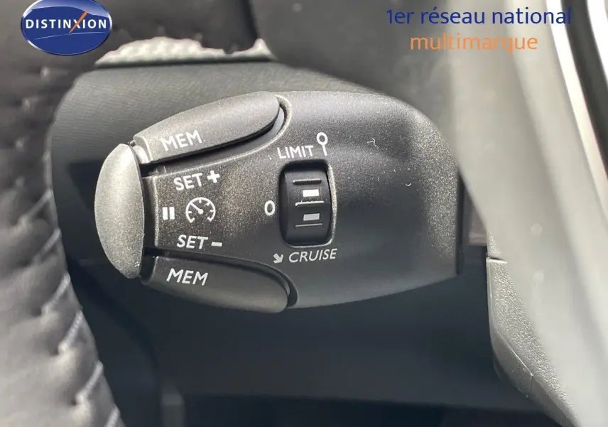 Gros plan sur la commande de régulateur de vitesse du Peugeot 208, côté gauche du volant, intérieur noir.