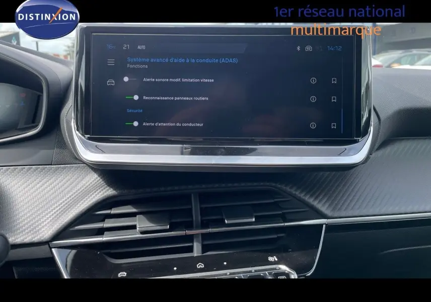 Vue rapprochée de l’écran tactile central du tableau de bord de la Peugeot 208, affichant les options d’aide à la conduite.