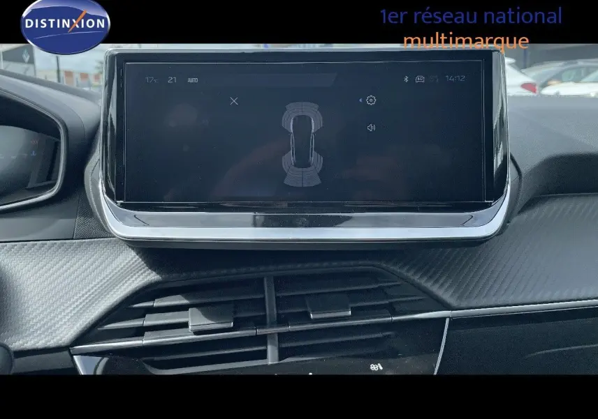 Vue intérieure centrée sur l'écran tactile du tableau de bord de la Peugeot 208 jaune Agueda Metal, version 2025.