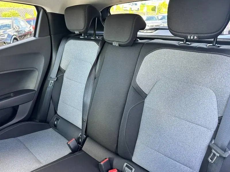 Vue intérieure arrière de la banquette grise et noire de la Renault Clio 2025 avec appuie-têtes et ceintures visibles.