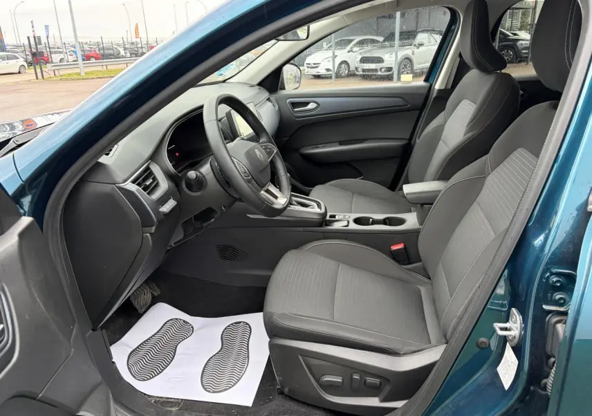 Vue intérieure côté conducteur de la Renault Arkana Bleu Zanzibar, sièges gris avec réglages électriques et volant textile.