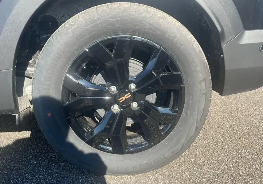 Gros plan sur la jante alu noire brillante côté avant droit du Dacia Jogger noir nacré 2024.