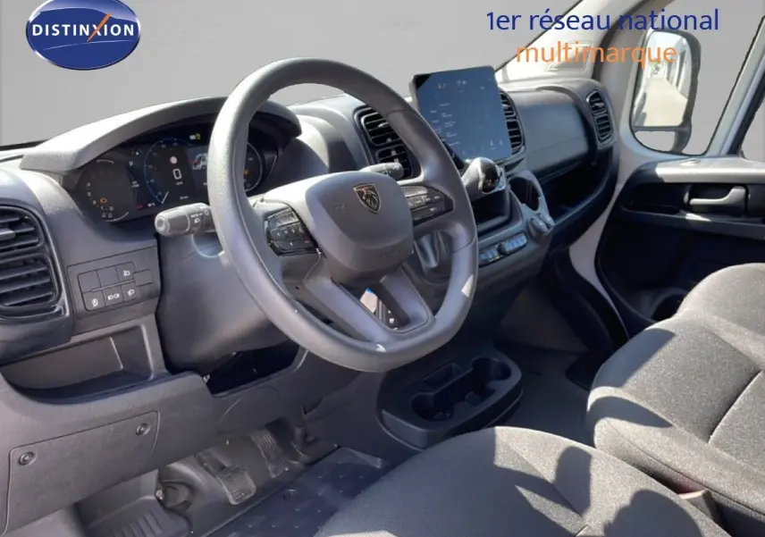 Vue intérieure côté conducteur du Peugeot Boxer Fourgon 2025, tableau de bord moderne avec écran tactile et volant multifonction.