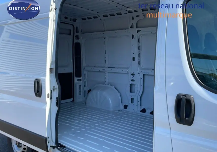 Vue latérale gauche du Peugeot Boxer Fourgon blanc banquise 2025 avec porte coulissante ouverte montrant l'intérieur vide.