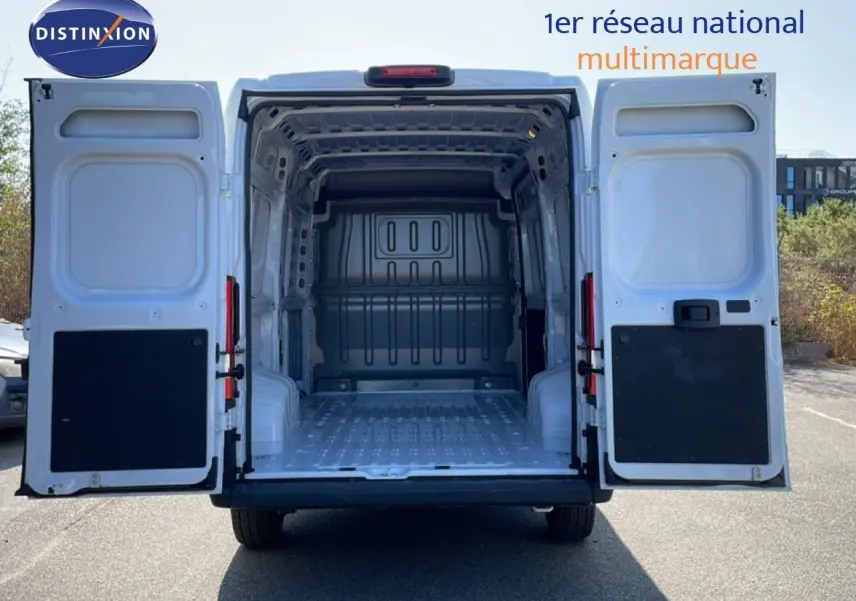 Vue arrière du Peugeot Boxer Fourgon blanc banquise 2025 avec portes ouvertes montrant la grande zone de chargement vide.